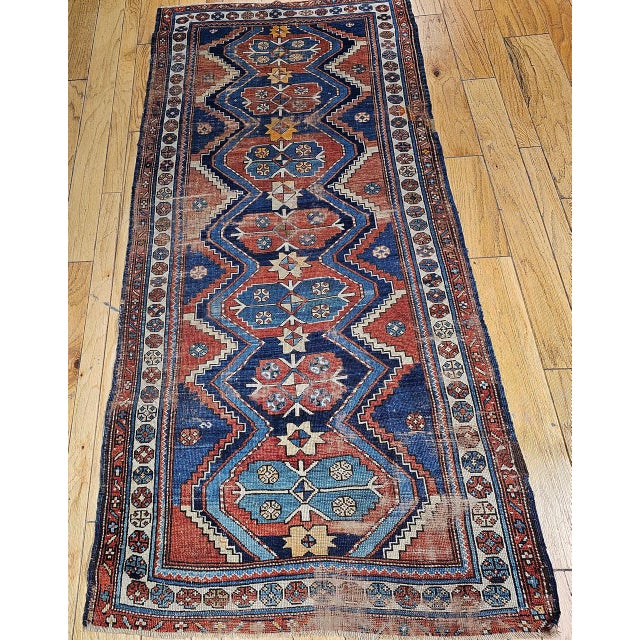 "Vintage Persian Kurdish tribal area rug or a wide runner, meticulously hand-knotted circa the early 1900s. Originating...