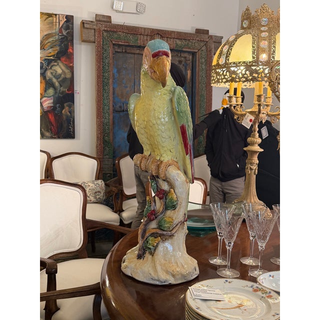 Gorgeous large majolica of a parrot on a faux bois trunk. The colors are soft and refreshing. The small repair on the beak...