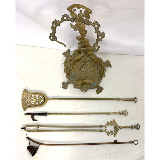 Wonderfully unique vintage French brass fireplace set from the mid 20th century. The heavy brass set has a hunting motif...