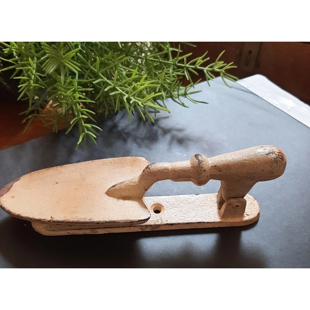 Delightful well made cast iron doorknocker. The design is a spade shovel. This would be amazing for a gardening shed or a...