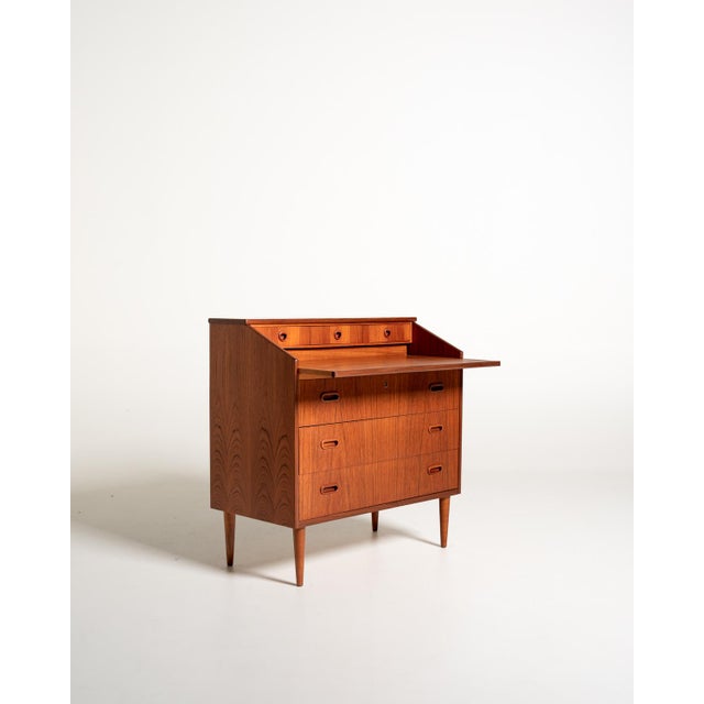 Teak secretary with three large drawers, a pull-out writing surface, and three small upper drawers. Made by Markaryds...
