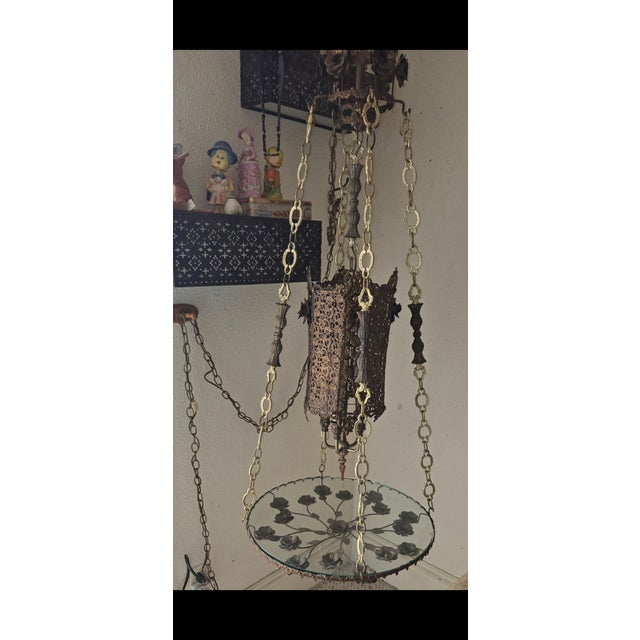 this lamp / chandelier hangs from the ceiling and is actually a round glass top swinging table. I believe it is one of a...