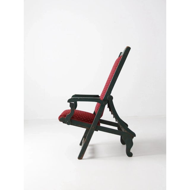 A Victorian lawn chair. The large antique wood chair features eight reclining positions. The wood frame is painted a...