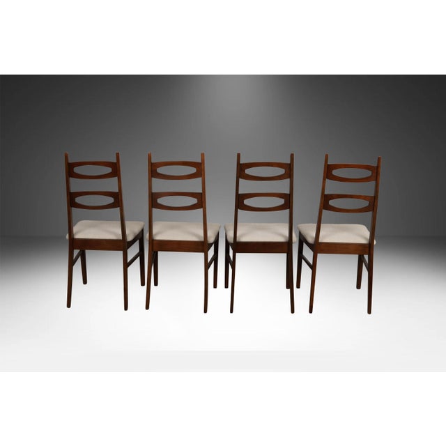 An outstanding set of four mid-century walnut dining chairs in the style of Kent Coffey "Perspecta" circa 1960’s. The...