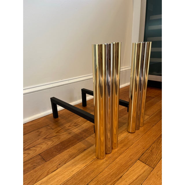 Stunning tubular andirons in brass and chrome. 3 substantial columns with 2 brass flanking 1 chrome. Chic and...