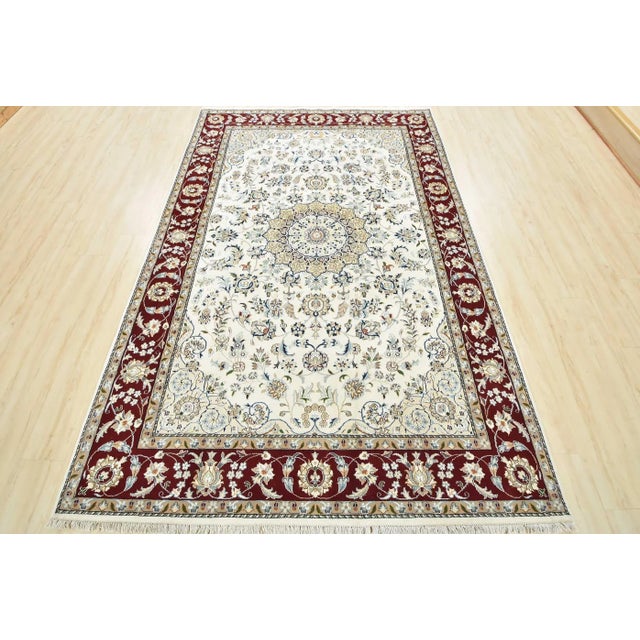 A traditional Nain rug hand-knotted with an all-wool pile on a cotton foundation. This finely woven oriental rug features...