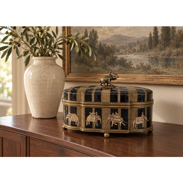 Impressive vintage decorative keepsake box by Castilian Imports, featuring an exotic elephant-procession design in black,...