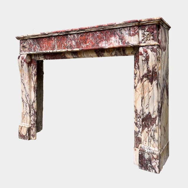 A large and highly variegated Breche de Saint Maximin marble fireplace from the very late 18th century. Rich in colours of...