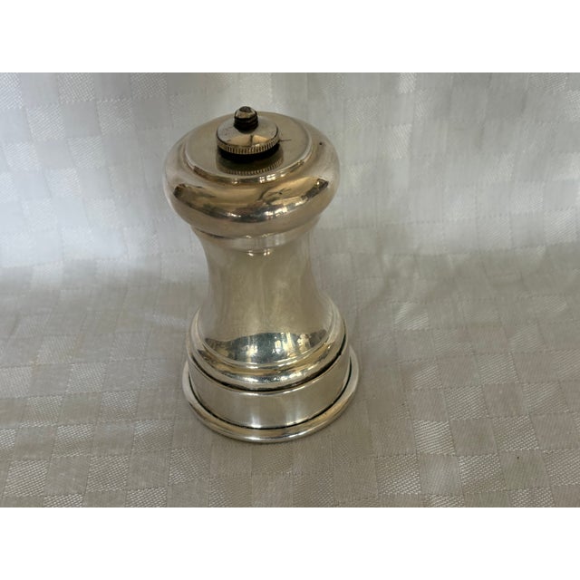 A sterling silver pepper mill. The top unscrews and the top lifts off so that it can be filled with peppercorns. The word...
