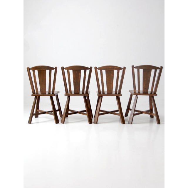 Set of four vintage mid-century wood dining chairs with a sculptural folk-inspired design, distinctive shaped legs, and a...