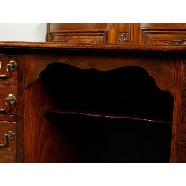 An English Georgian period mahogany desk from the 19th century, with 10 graduating drawers and brass hardware. Created in...
