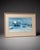 Large framed coastal boardwalk print featuring a soft blue beachside building scene with an airy, calm, and relaxed...