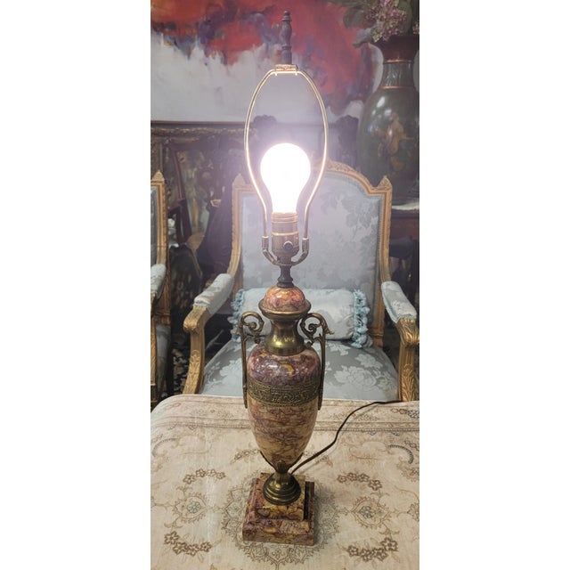 A beautiful Grecian style marble and guilt bronze urn form table lamp. Features bronze handles and bronze wrapped frieze...