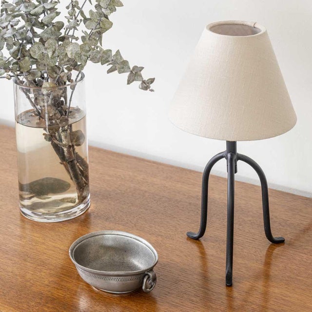 Petite iron tripod lamp with slender legs and tapered feet. New wiring and new linen shade. Sold individually and newly...