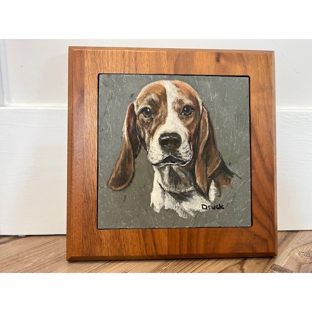 Brown-and-white beagle rendered on a textured gray slate tile, mounted inside a warm-toned wooden frame. specializes in...