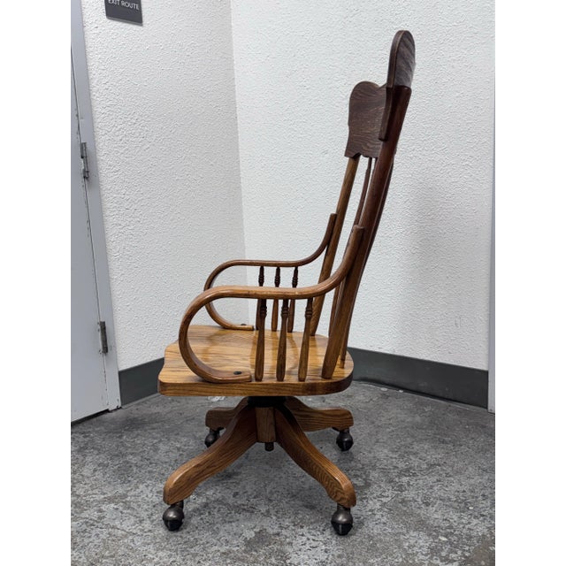 Design Plus Gallery presents a Tiger Oak Swivel Bankers Chair from the Mid 20th Century, or Easier. It rolls, swivels and...