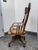 Design Plus Gallery presents a Tiger Oak Swivel Bankers Chair from the Mid 20th Century, or Easier. It rolls, swivels and...