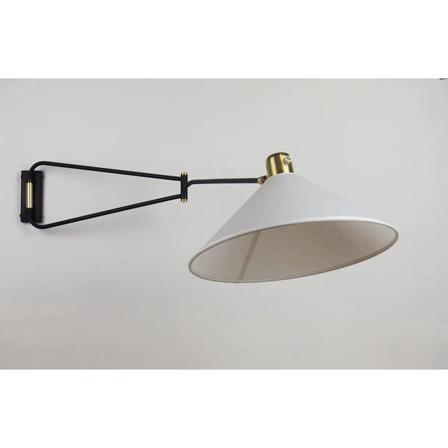 Large wall light articulated in three points: the arm is adjustable on the base, the rod supporting the lampshade is also...