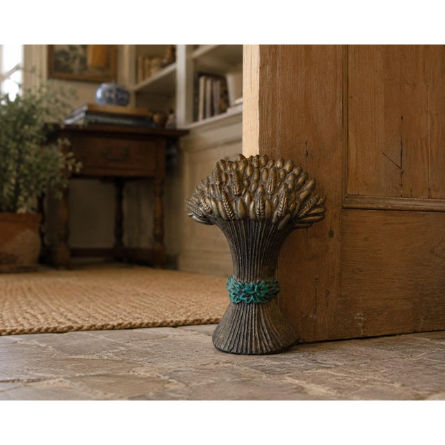 A substantial vintage cast iron doorstop modeled as a gathered sheaf of wheat, with individually cast grain heads,...