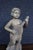 Italian figure depicting a standing putti playing a mandolin while standing atop a rocky naturalistic base. Finished in...