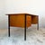 Twin-pedestal desk with two banks of two drawers, each fitted with satin brass handles. Black steel frame with tapered...