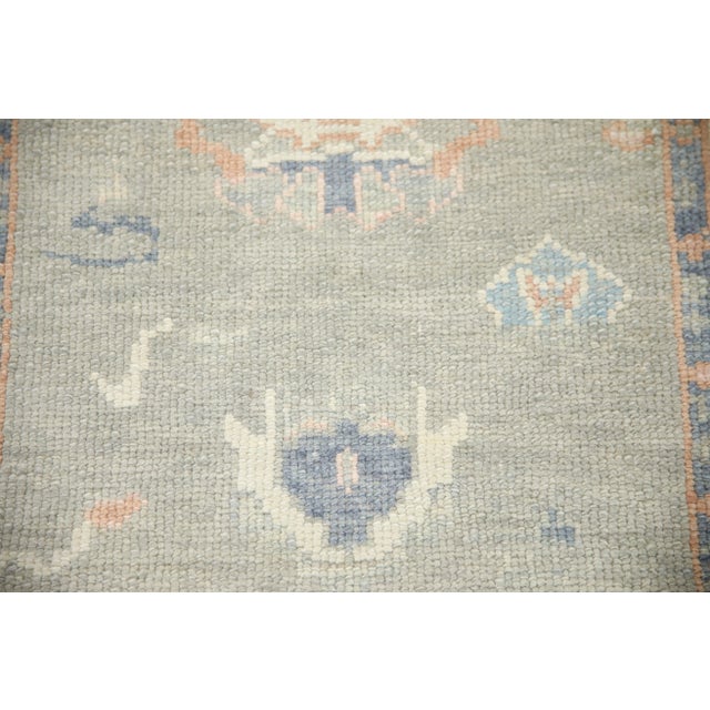 This modern Turkish Oushak rug is a stunning piece of art that has been handwoven using traditional techniques by skilled...