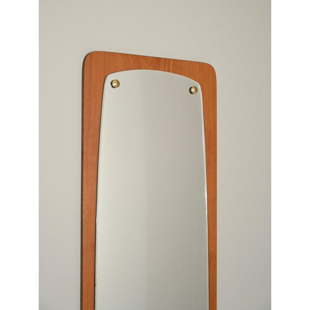Elongated wall mirror with teak wood frame. Good vintage condition. The glass is partially oxidized. This piece has an...