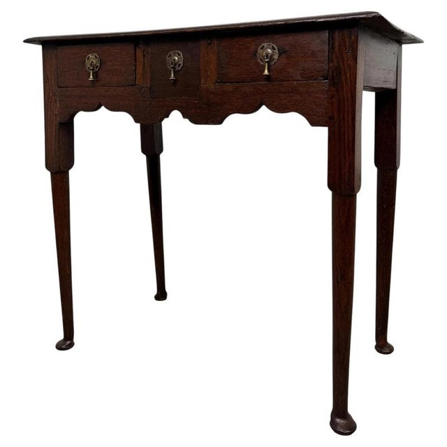 A handsome 18th-century English side table, finely crafted from oak and distinguished by its elegant turned legs,...