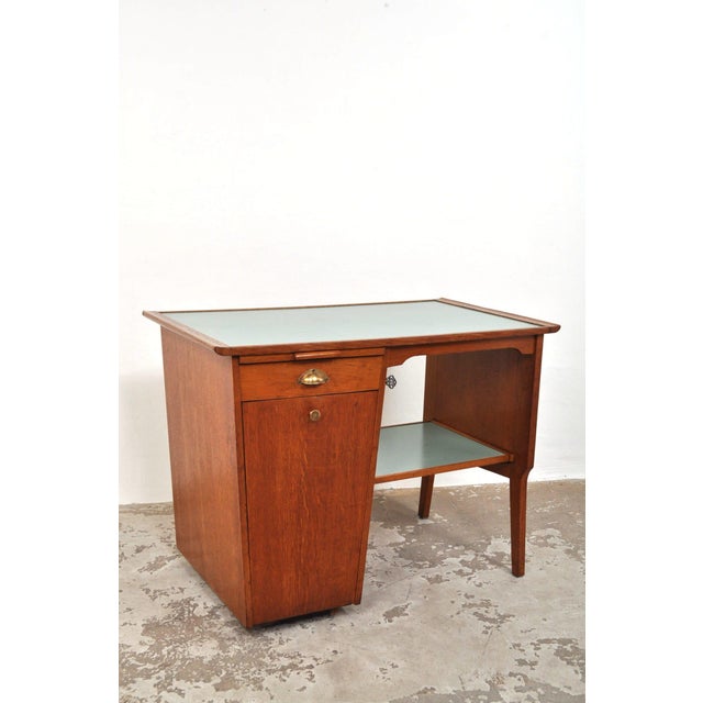 A unique and ingeniously designed desk! this elegant oak desk with a green formica top features a pull-out tray on the...