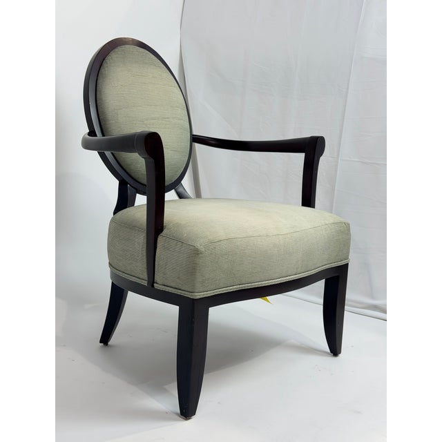 This is an elegant armchair designed by Barbara Barry for Baker Furniture, defined by its timeless oval medallion back and...