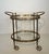 This beautiful and elegant neoclassical style oval bar cart is made of brass with glass tops. It is a French work by...