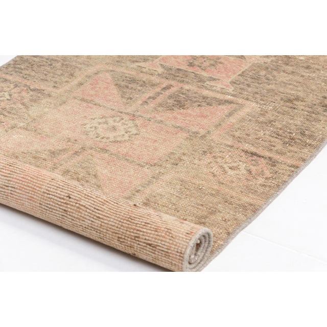 This is a vintage Turkish Oushak rug from the Mid 20th Century. The piece was hand-knotted.