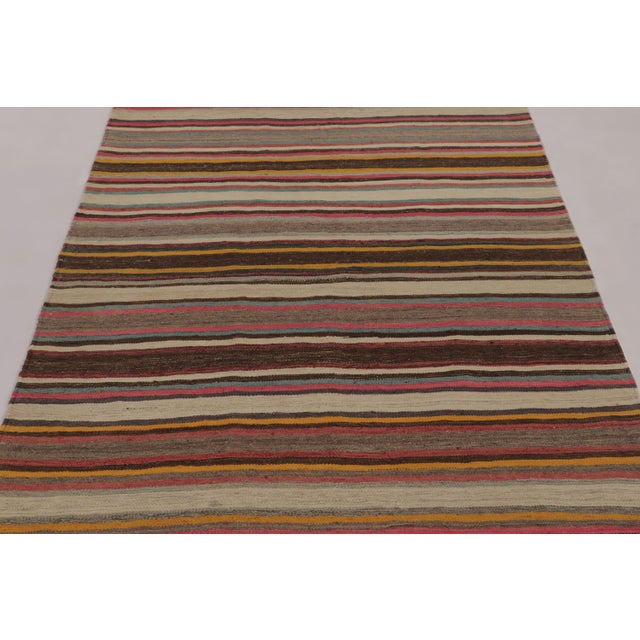 Made with handwoven wool circa 1950-1960, this 5x7 vintage flat-weave Kilim is a particularly cheerful and sought-after...