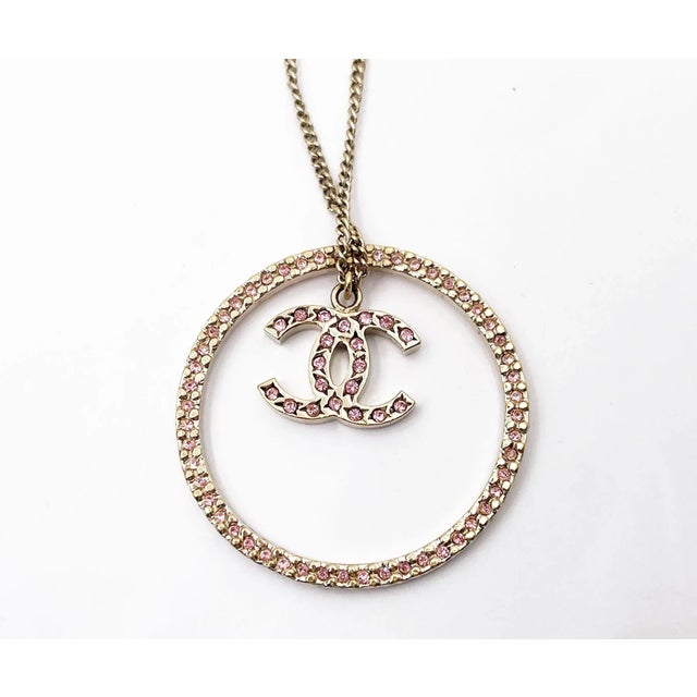 This is part of Chairish’s Costume Jewelry assortment. Chanel Gold CC Pink Crystal Ring Pendant Necklace * Marked 06 *...