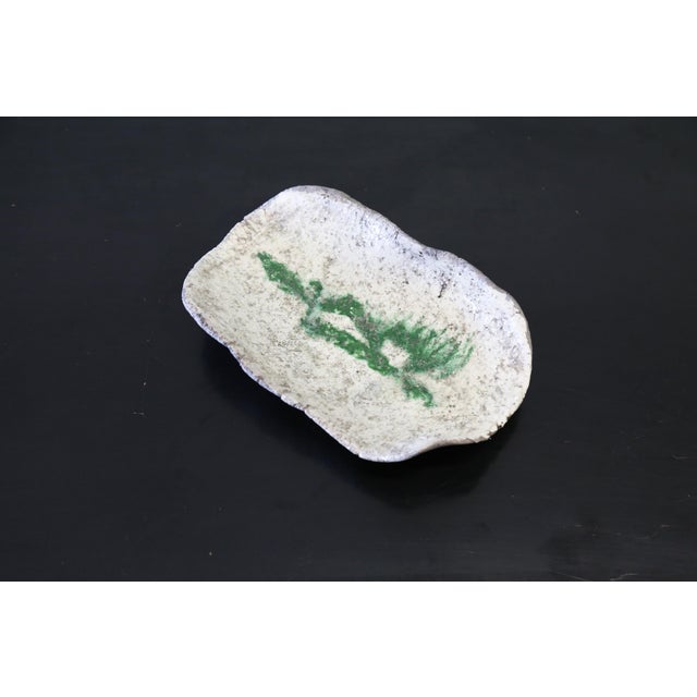 A studio made ceramic catch all, tray featuring a free form abstract green glazed center on a blanket free form body of...