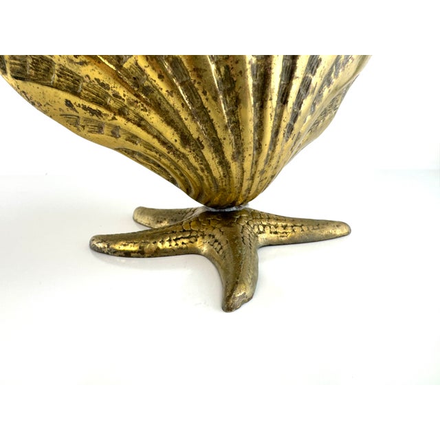 Vintage brass clamshell dish raised on a sculptural starfish base, blending naturalistic coastal form with a glamorous...