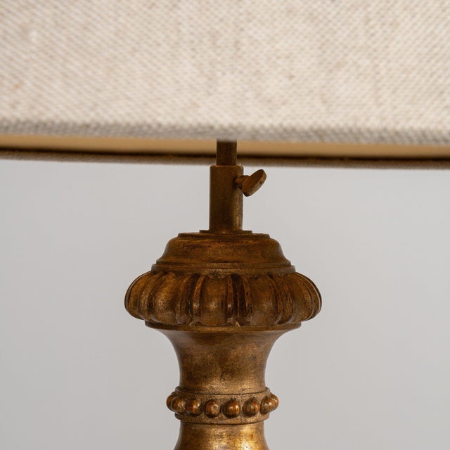 Carved giltwood floor lamp in Antique Gold. The antique gold surface highlights ornate carved column, gilt finish,...