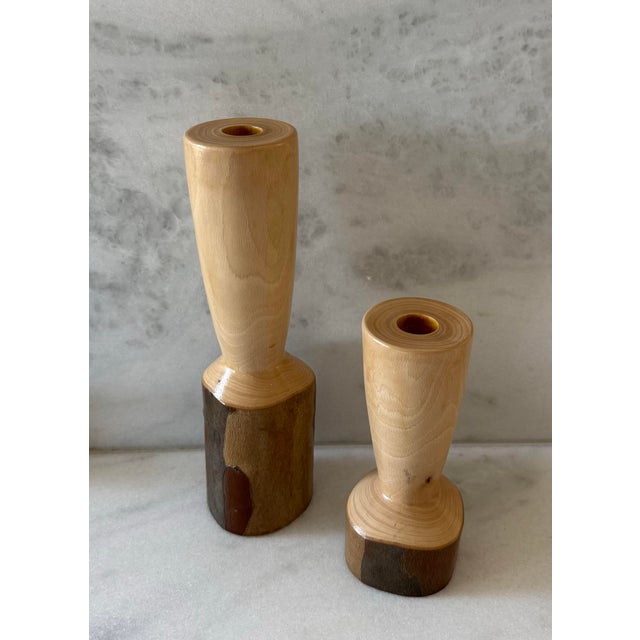 Pair of vintage handcrafted turned wood candle holders made of a light toned wood and natural darker live-edge or bark-...