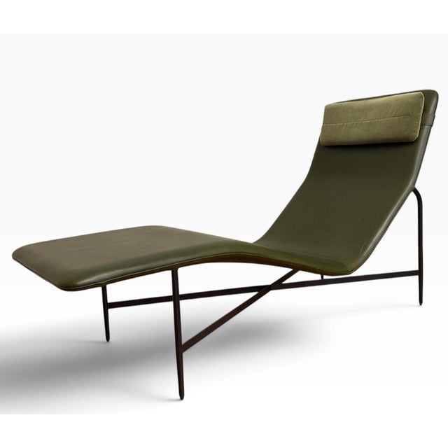 A sculptural “Deep Thoughts” chaise lounge by Blu Dot, finished in a rich loden green aniline leather and accompanied by a...