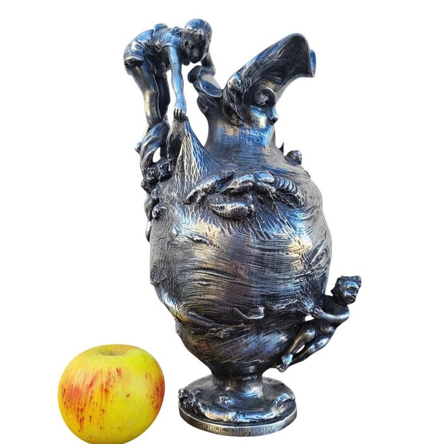 Large pewter ewer, on the theme of the sea: the catch represents a woman lifting a fishing net in which she has caught...