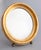 A stylish Mid-Century Italian giltwood oval vanity or dressing table mirror, circa 1950. This gorgeous mirror has a sleek...