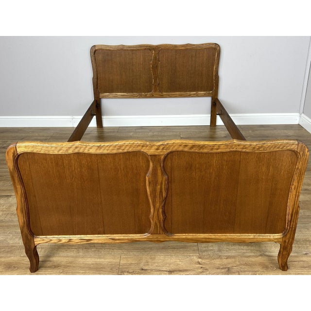 A charming Vintage French Louis double bed frame in oak , featuring elegantly shaped headboard and footboard panels with...