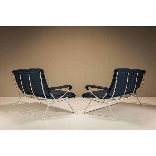 Lightness defines this pair of du 57 sofas by mario rinaldi for mim roma. New dark blue upholstery meets an ivory-coloured...