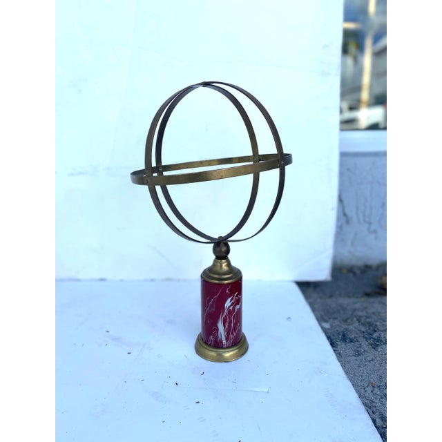 A brass armillary resting on a wonderful marbleized painted base. A classic with a modern twist