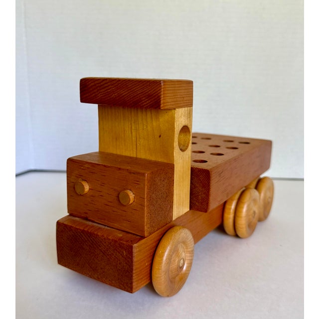 Here is a handcrafted wooden toy truck by Sam Sellers, showcasing the warmth and character of natural wood in a...