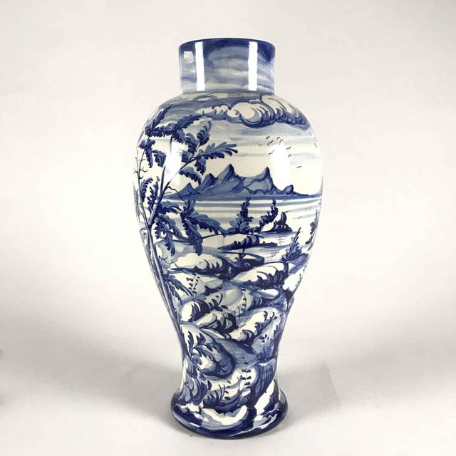 A Taccini family white and blue ceramic vase from Vinci, 1976, featuring a richly decorated lake landscape with boats, all...