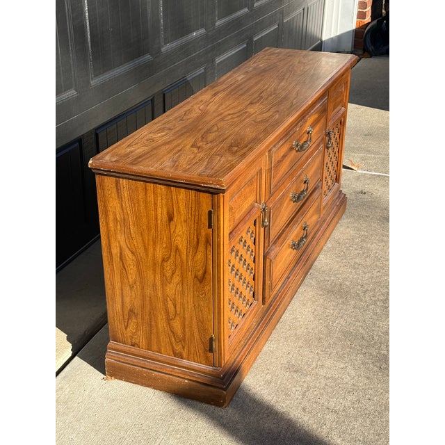 A classic vintage-style buffet or console showcasing warm wood veneer, decorative cane-style lattice door fronts, and...