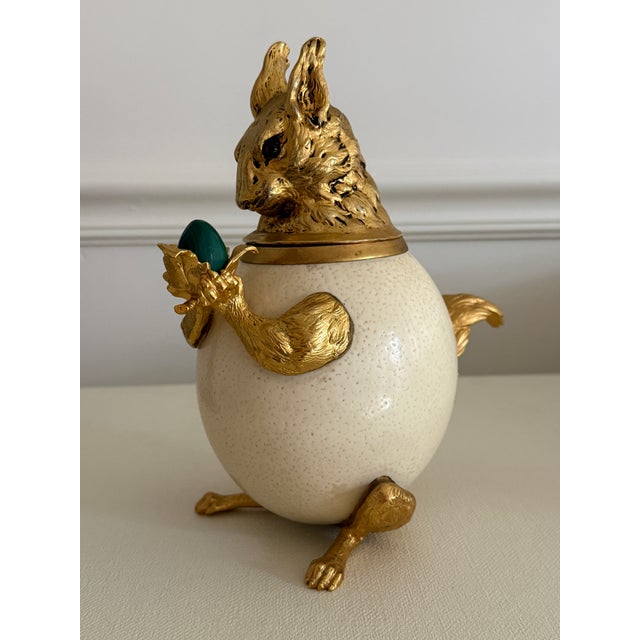 Large gilded over silverplate squirrel box. The body is an ostrich egg. He holds a malachite acorn. Fine detailing in the...