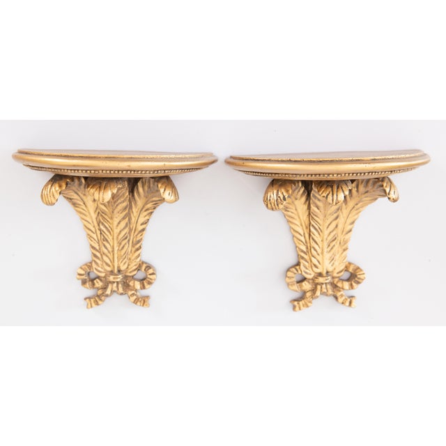 A lovely vintage pair of Italian gilt resin wall brackets or shelves. These stylish brackets have scrolling feathers with...