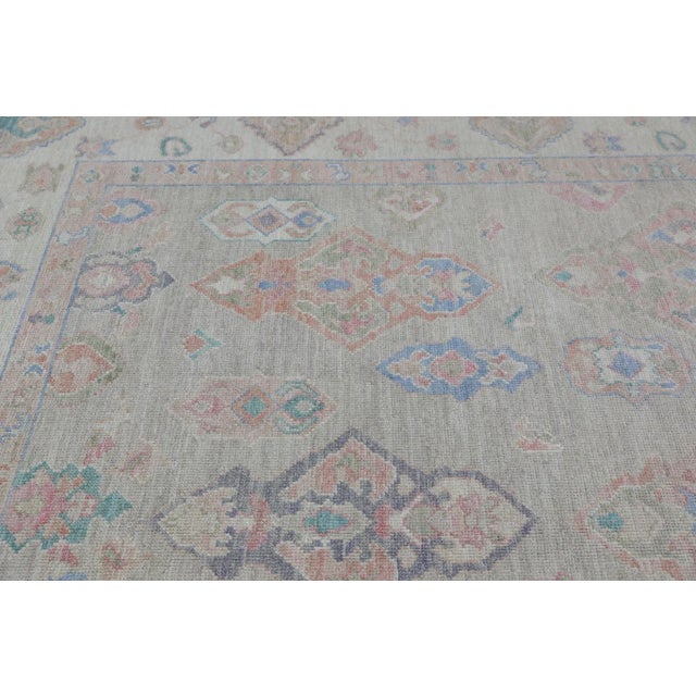 This modern Turkish Oushak rug is a stunning piece of art that has been handwoven using traditional techniques by skilled...